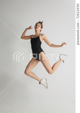 Beautiful young woman's portrait isolated on grey studio background. Having fun, happy, full length 72622030