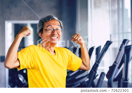 Senior Asian Man showing off muscle for strong healthy lifestye concept in a fitness gym. Senior Asian Man showing off muscle for strong healthy lifestye concept in a fitness gym. 72622301