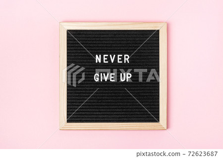 Never Give Up. Motivational quote on black background Stock Photo