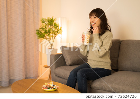 A woman enjoying a movie at home 72624726