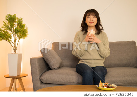A woman enjoying a movie at home A woman enjoying a movie at home 72625345