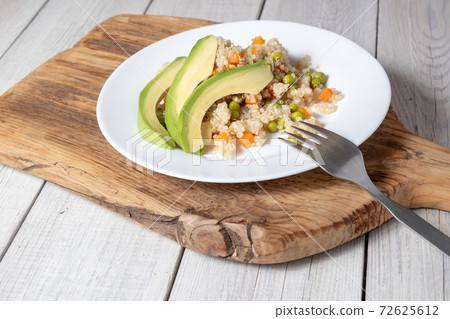 Quinoa porridge with vegetables and avocado in a white flat plate on a 72625612