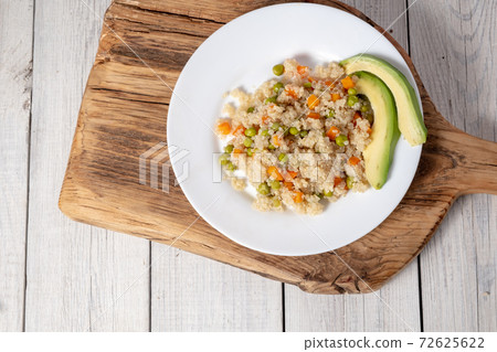 Quinoa porridge with vegetables and avocado in a white flat plate on a 72625622