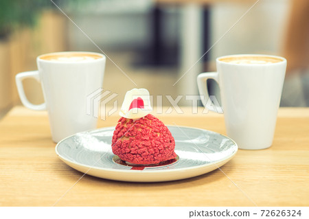 Piece of red cake with two cups of coffee on wooden table in the cafe. 72626324