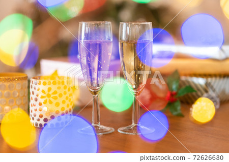 Presents and champagne lined up on the table in front of the Christmas tree 72626680