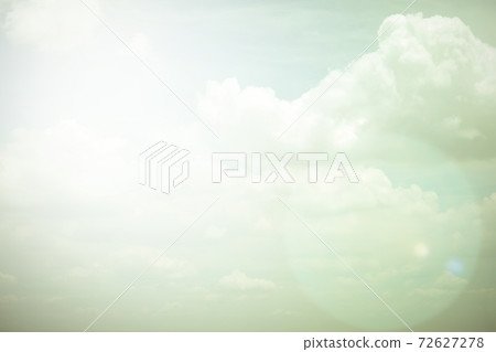 Sky with soft fluffy clouds in vintage color tone with sun flare Sky with soft fluffy clouds in vintage color tone with sun flare 72627278