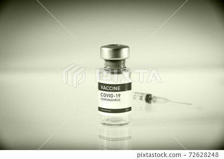 Covid-19 vaccine bottle and syringe on a black and white background Covid-19 vaccine bottle and syringe on a black and white background 72628248