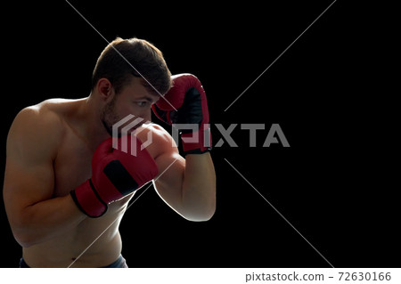 Young boxing fighter on black 72630166