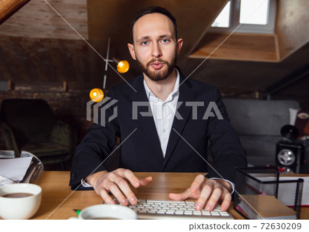 Young man talking, working during videoconference with colleagues at home office 72630209