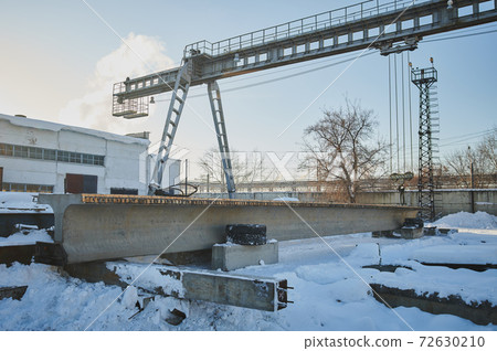 Row of reinforced concrete foundations with metal anchor bolts designed for the installation of metal columns. Foundations of warehouse on the construction site. 72630210