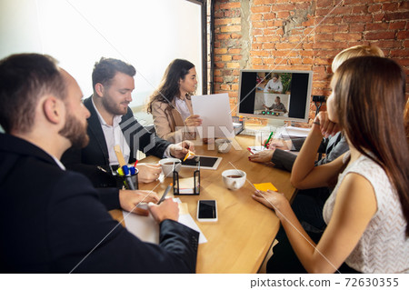 Young people talking, working during videoconference with colleagues at office or living room 72630355