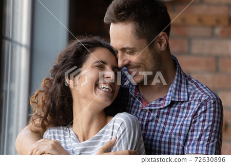 Caring young husband hugging shoulders of beloved wife with affection 72630896