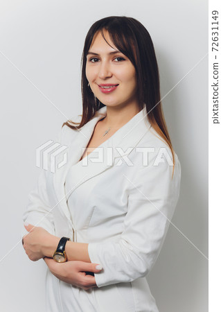 Portrait of attractive smiling female dentist with hands folded. 72631149