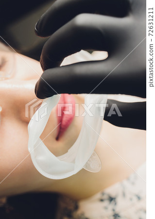Close-up photo of a disposable dental rubber dam used for keeping soft tissues of mouth safe from dental tools. Close-up photo of a disposable dental rubber dam used for keeping soft tissues of mouth safe from dental tools. 72631211