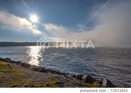 A bridge in fog. Blue ocean and mist in the background. Picture from the bridge connecting Sweden with Denmark A bridge in fog. Blue ocean and mist in the background. Picture from the bridge connecting Sweden with Denmark 72631602