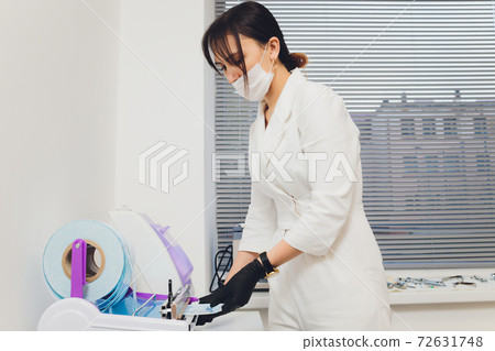 Portrait of attractive smiling female dentist with hands folded. 72631748