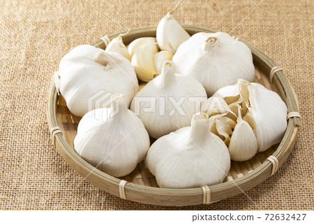 Garlic lined up on a colander with linen Garlic lined up on a colander with linen 72632427
