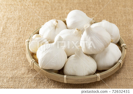 Garlic lined up on a colander with linen 72632431