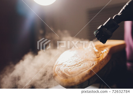 washing the dirty cleaning the shoes with a steam cleaner. 72632784