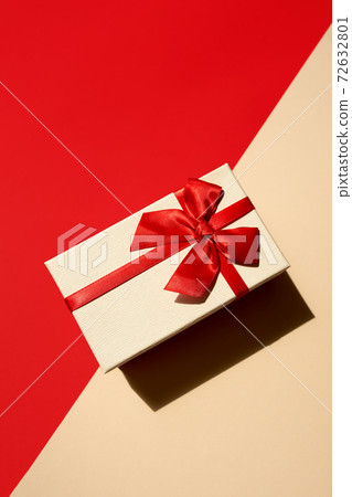 White present with red ribbon on the bright red background 72632801