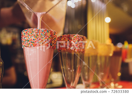 Glasses of milkshake, frappe, ice coffee and smoothie with whipped cream. Glasses of milkshake, frappe, ice coffee and smoothie with whipped cream. 72633380