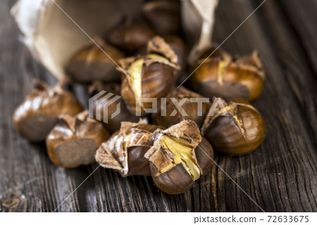 Chestnuts on wooden background 72633675