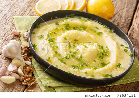 Delicious Greek Skordalia made from mashed potatoes with garlic, lemon, nuts and olive oil close-up in a plate. horizontal 72634131