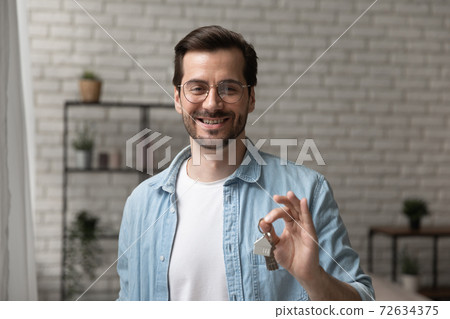 Friendly man broker posing with keys of flat for sale 72634375