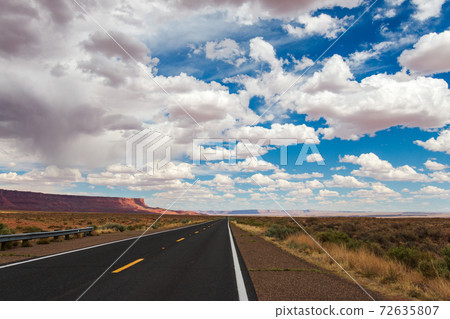 Empty road in the Arizona desert with big clouds and blue sky Empty road in the Arizona desert with big clouds and blue sky 72635807
