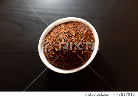 Rooibos tea on white plate on a wooden table Rooibos tea on white plate on a wooden table 72637010