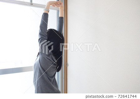 A woman stretching while bathing in the morning sun by the window A woman stretching while bathing in the morning sun by the window 72641744