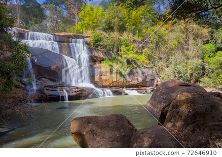 Waterfall with stone foreground in forest Waterfall with stone foreground in forest 72646910