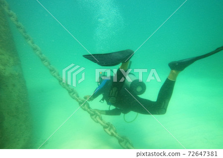 Male scuba diver with equipment diver swims in water Male scuba diver with equipment diver swims in water 72647381