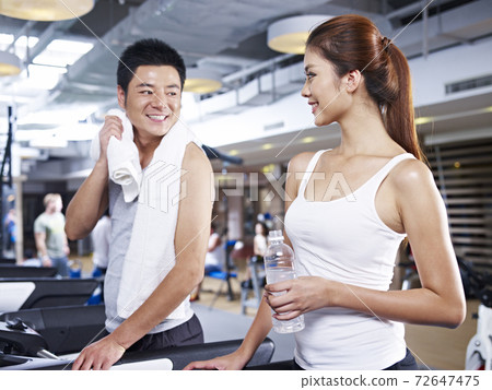 young man and woman talking during a break in gym. 72647475