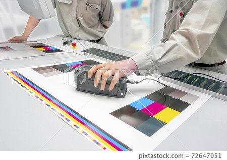 Hands of two engineers who measure the color of printed matter, color management, color management, quality control image Hands of two engineers who measure the color of printed matter, color management, color management, quality control image 72647951