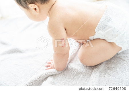 Baby with BCG marks on his arm sitting by the window Baby with BCG marks on his arm sitting by the window 72649308