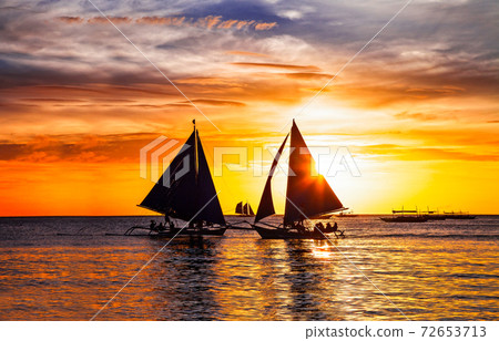 amazing tropical sunset and silhouette of sailing boats in Boracay island in Philippines 72653713