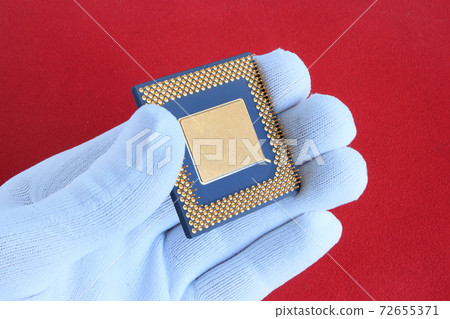 Hand in white glove holds a computer chip. 72655371