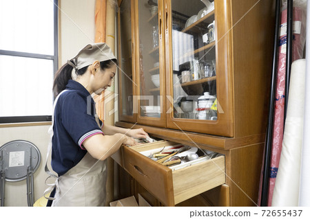 Workers cleaning up a messy room 72655437