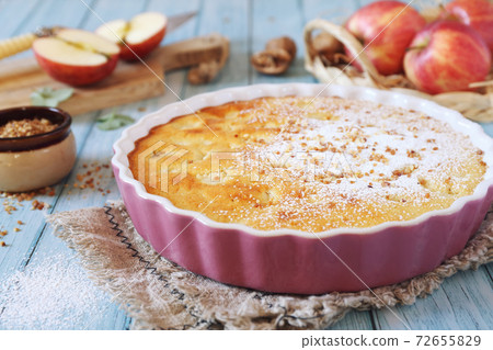 Apple clafoutis pie with praline in ceramic dish for sweet dessert and fresh apples Apple clafoutis pie with praline in ceramic dish for sweet dessert and fresh apples 72655829