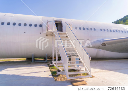 Passenger stair with boarding ramp steps. Commercial airplane, aircraft with blue sky background in travel trip and transportation concept. Flying vehicle. 72656383
