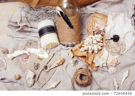 a lot of sea theme in mess like shells, candles, perfume, girl stuff on linen, pretty textured post card view vintage 72656450