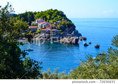 Coastal city. Small old houses with a tiled roof near the sea on the mountain. Montenegro. Adriatic Sea. Coastal city. Small old houses with a tiled roof near the sea on the mountain. Montenegro. Adriatic Sea. 72656835