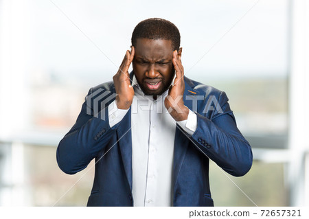 Young afro american businessman touching head. 72657321