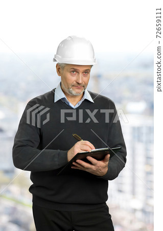 Mature architect looking on object. 72659111