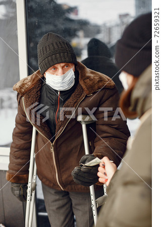 Disabled homeless man on crutches in old clothes Disabled homeless man on crutches in old clothes 72659321