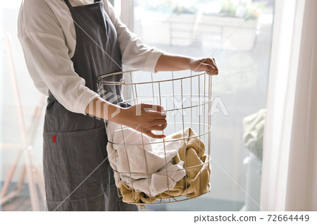 Image of a woman doing housework and laundry 72664449