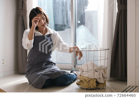 Image of a woman who feels tired and stressed about housework Image of a woman who feels tired and stressed about housework 72664460