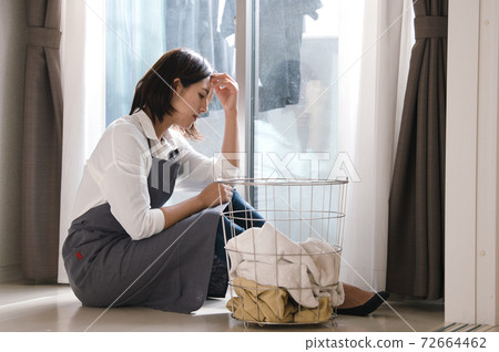 Image of a woman who feels tired and stressed about housework 72664462