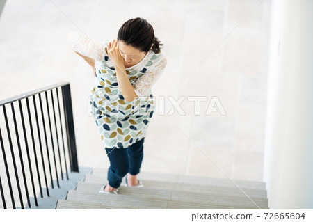 A woman who has a pain in her body and has difficulty climbing stairs 72665604